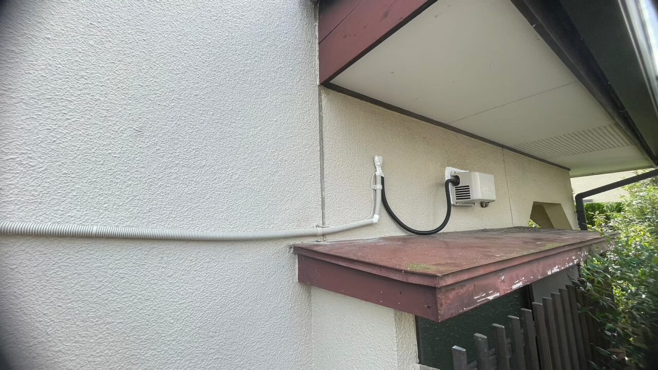 外壁に新設した浴室暖房機用の配管と電源工事の様子｜後付け工事のためのコア抜き施工