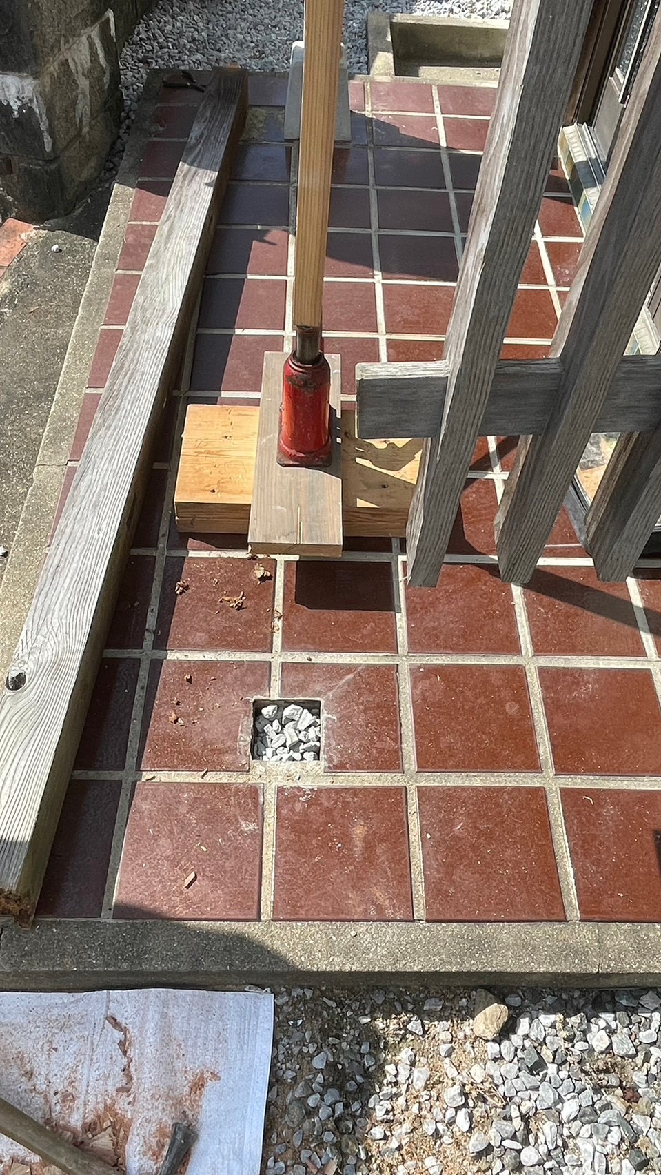 劣化した束石を撤去し、新しい支柱設置のための基礎を加工している作業写真｜玄関屋根支柱交換工事
