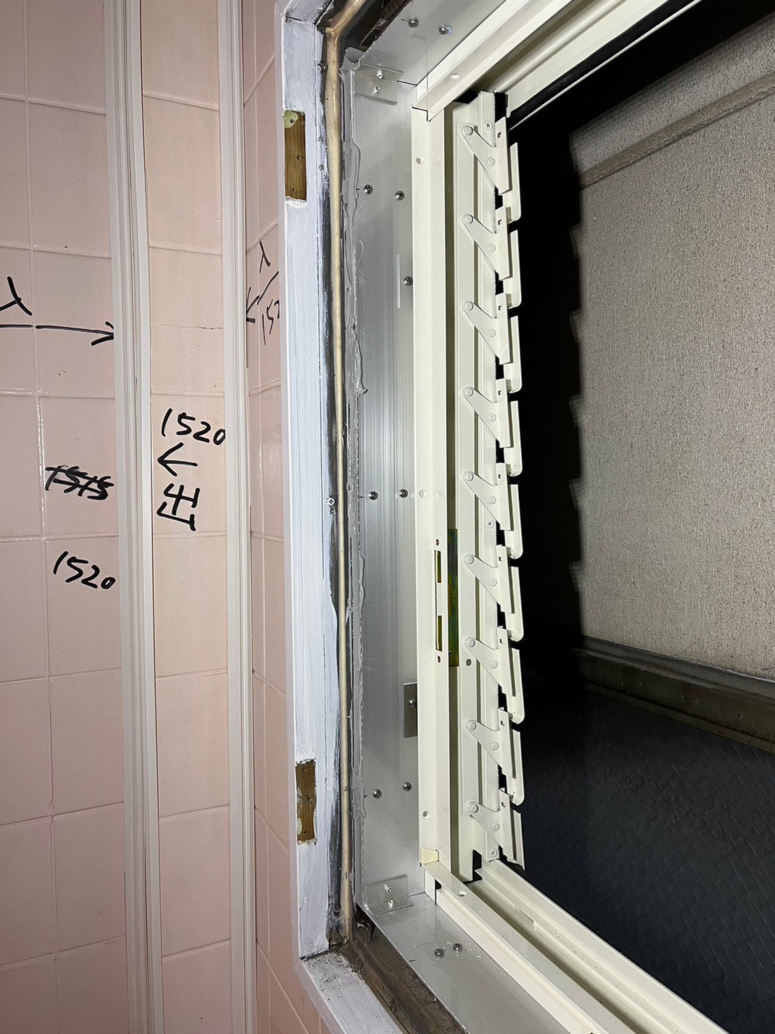 既存トイレ窓まわりの寸法を計測している様子|窓交換工事前のサイズ確認作業