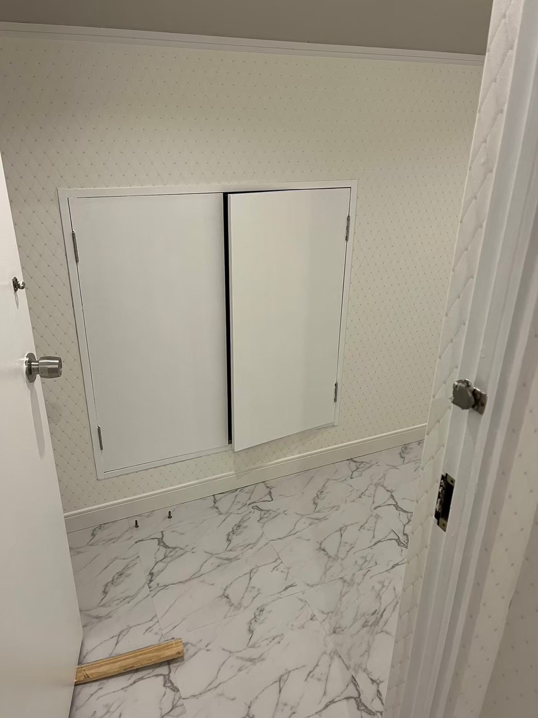 内開き観音扉を取り付けた施工途中の写真|店舗廊下の窓を扉化する造作工事